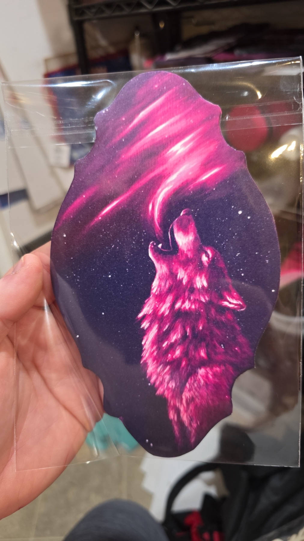 Pink skull-shaped die-cut print held in a hand